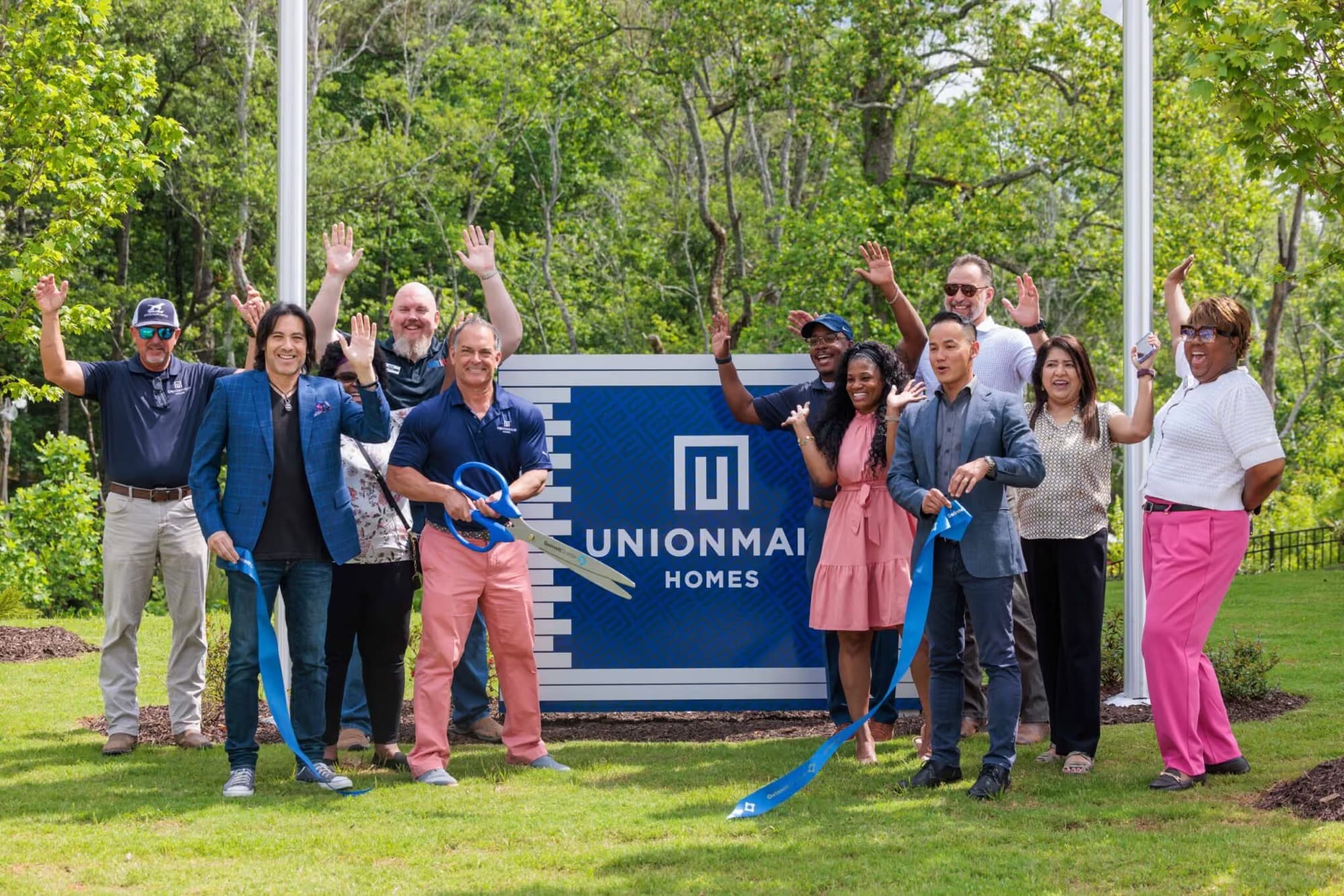 UnionMain Homes team celebrating together at an Atlanta community ribbon cutting